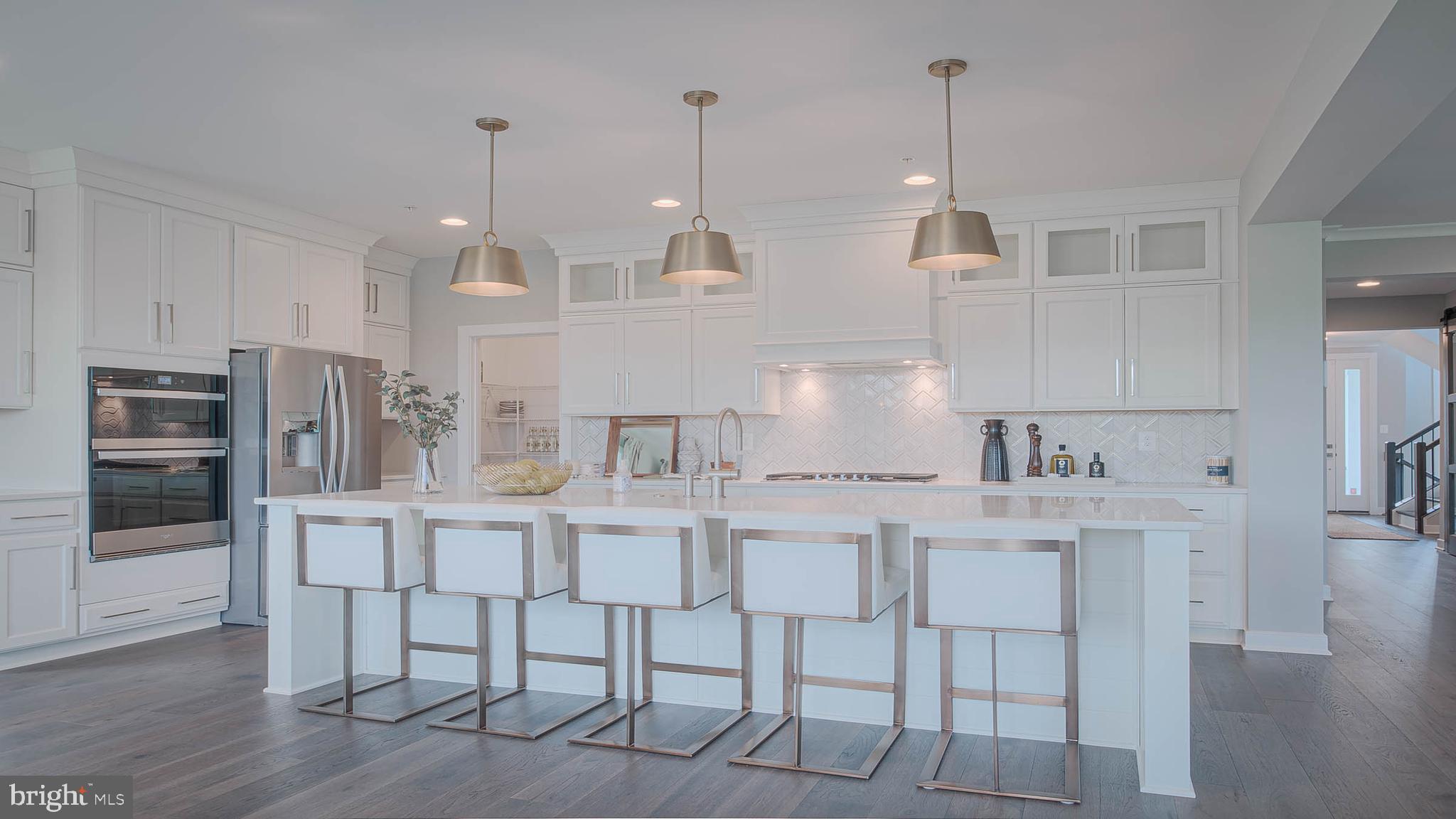 8785 Helleber Spring Circle Frederick, MD 21701 - Photo 5 of 22 a kitchen with stainless steel appliances granite countertop a kitchen island a stove a table and chairs