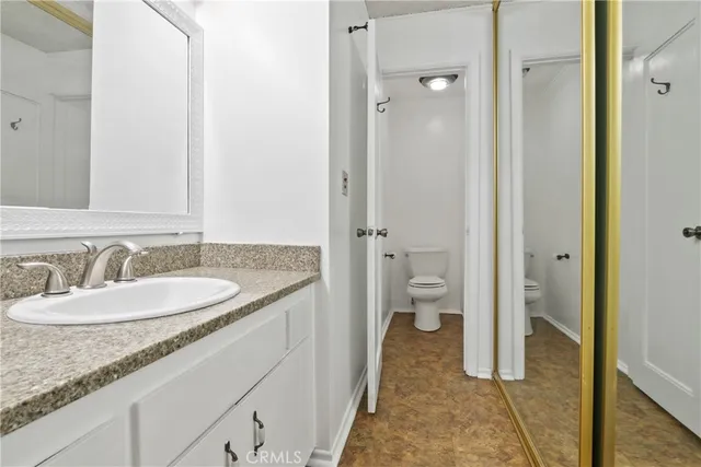 a bathroom with a granite countertop sink and a mirror