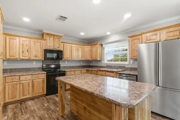 a kitchen with stainless steel appliances granite countertop a sink stove microwave and refrigerator
