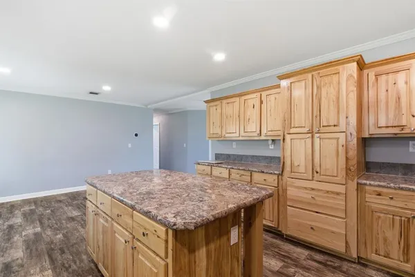 a kitchen with granite countertop a sink a counter top space appliances and cabinets