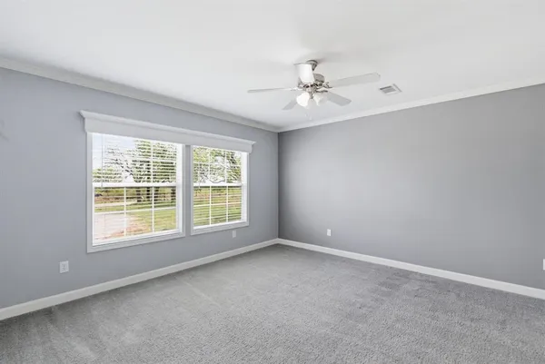 an empty room with closet and a ceiling fan