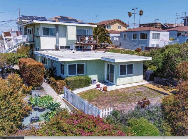 a front view of a house with a yard and outdoor seating