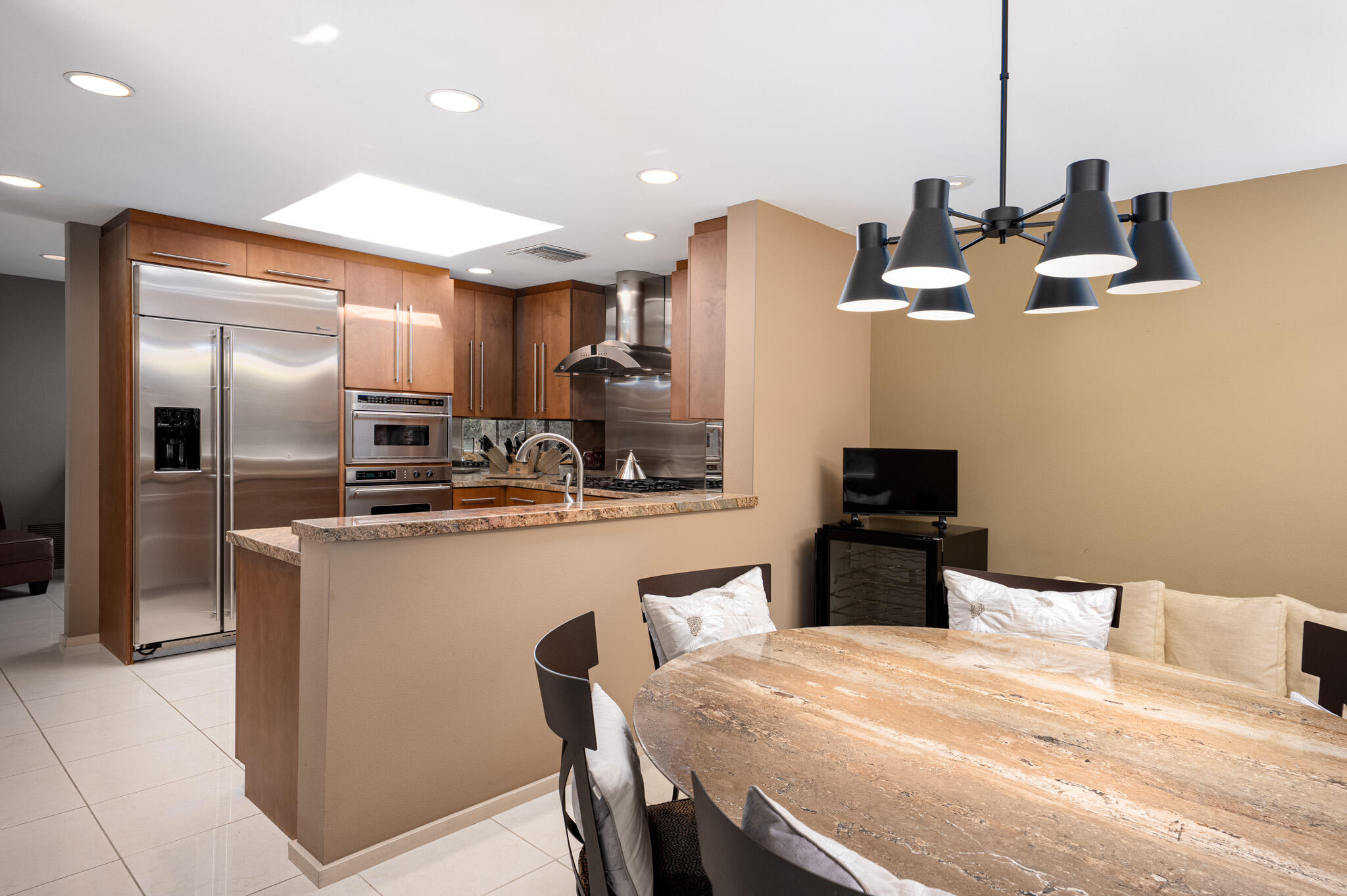 52 Princeton Drive Rancho Mirage, CA 92270 - Photo 12 of 52 a kitchen with stainless steel appliances kitchen island granite countertop a refrigerator a stove a sink a dining table and chairs with wooden floor