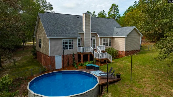 a view of a house with swimming pool and a yard