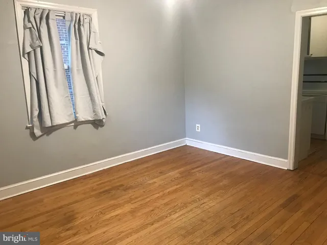 a view of a room with wooden floor and white walls