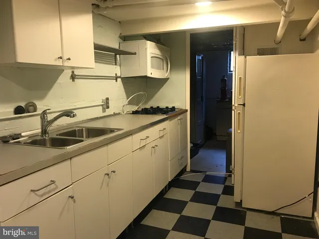 a kitchen with a sink a stove and cabinets