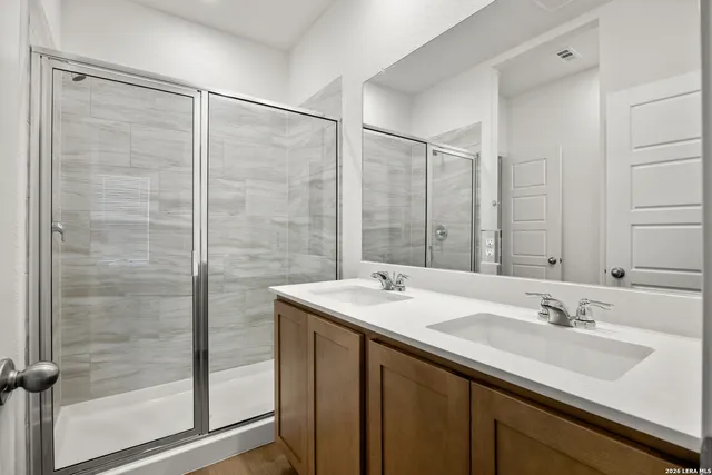 a bathroom with a sink double vanity and a shower