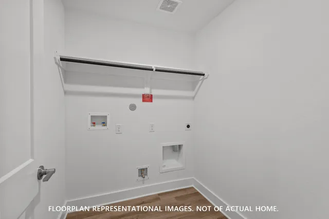 a view of a big room with wooden floor and windows