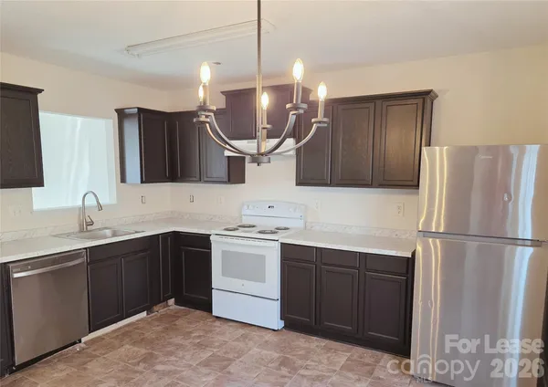 a kitchen with a sink a stove a refrigerator and cabinets