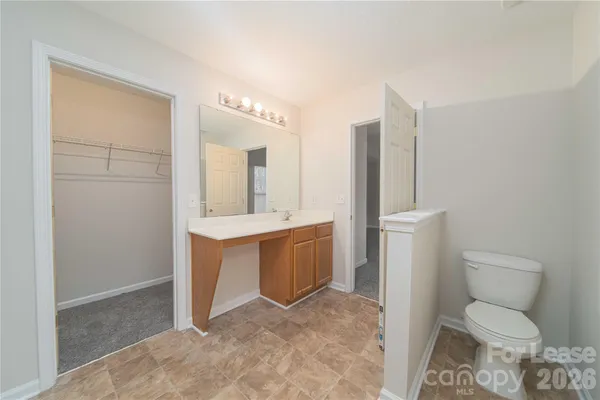 a spacious bathroom with a toilet sink and mirror
