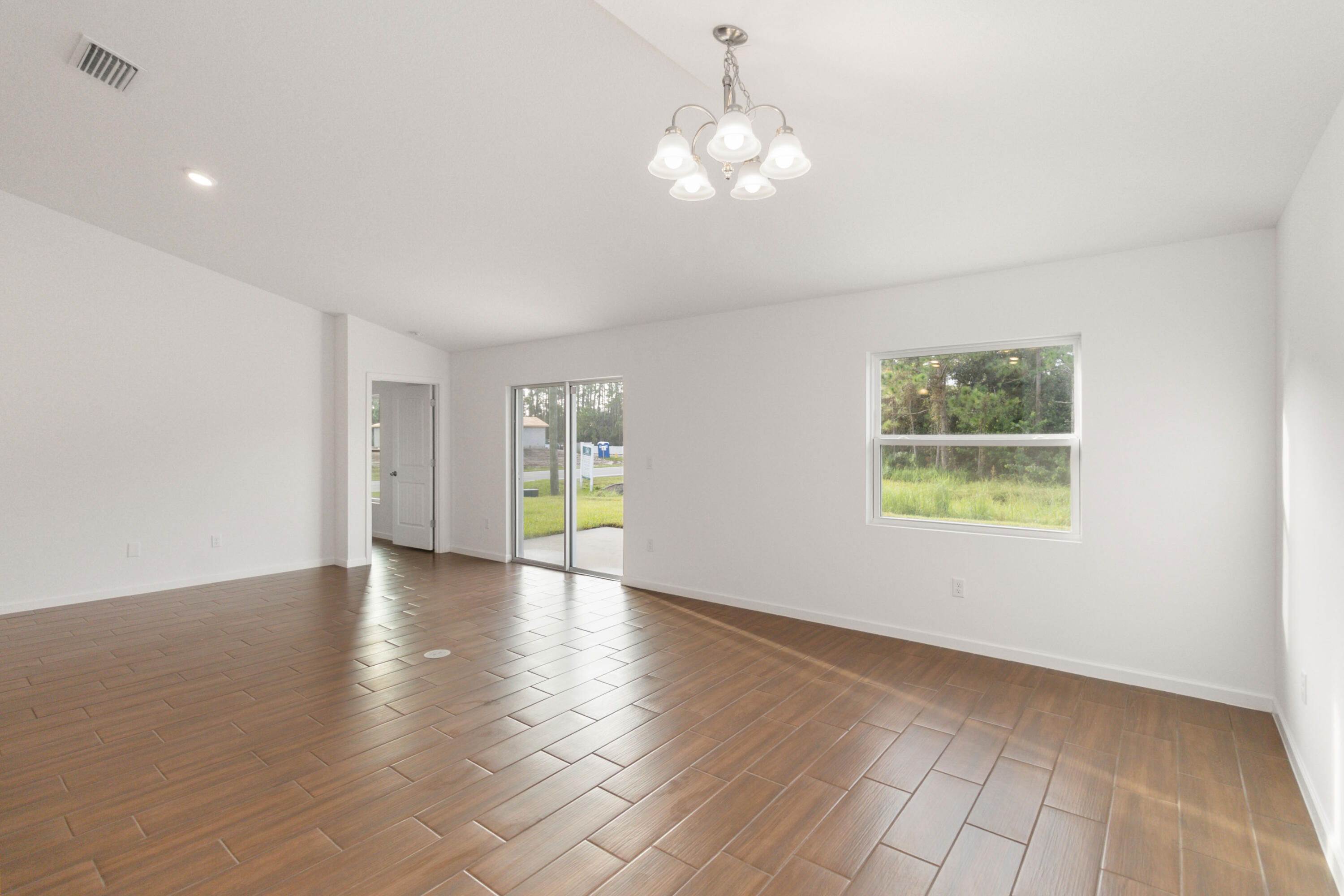 336 Rheine Road Northwest Palm Bay, FL 32907 - Photo 16 of 30 an empty room with wooden floor and windows