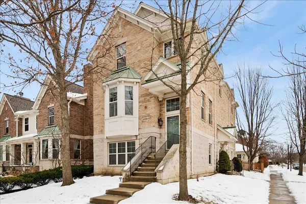 a front view of a building with large trees