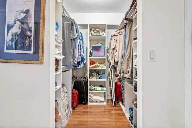 a bedroom with a bed a dresser and wooden floor