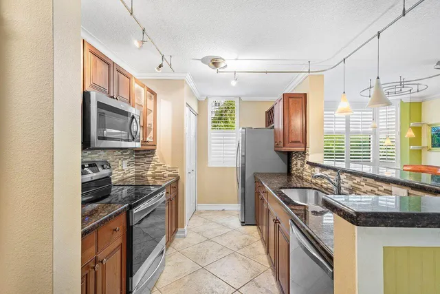 a kitchen with stainless steel appliances granite countertop a sink and a stove