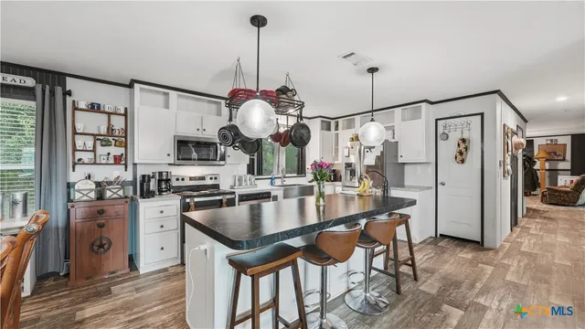 a kitchen with stainless steel appliances granite countertop a sink a stove and a refrigerator