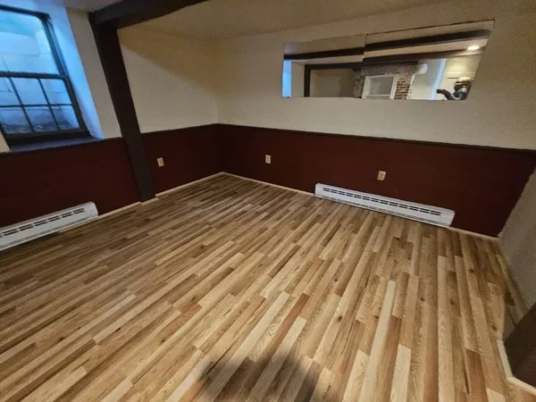 a view of a room with wooden floor
