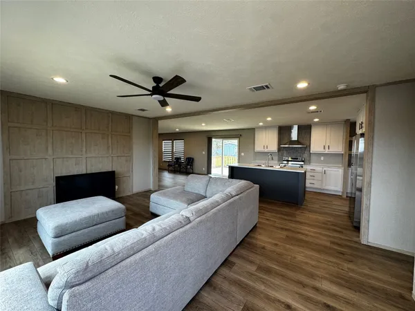a living room with furniture and kitchen view