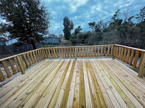 a view of balcony with wooden floor and fence