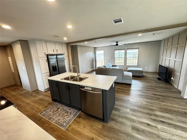 a kitchen with stainless steel appliances granite countertop a sink a stove a refrigerator and island