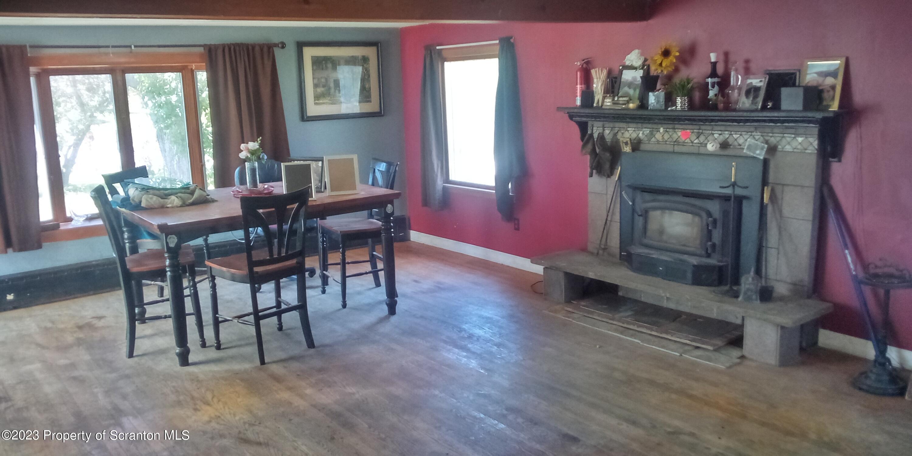 28 Williams Pond Road Montrose, PA 18801 - Photo 19 of 38 a dining room with furniture a fireplace and wooden floor