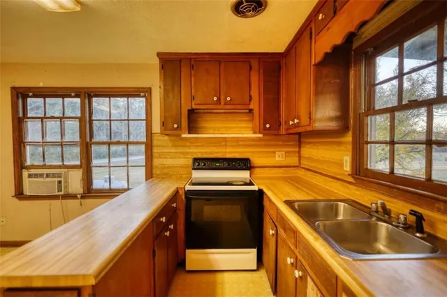 a kitchen with stainless steel appliances a sink stove and cabinets