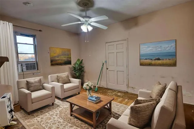 an empty room with a chandelier fan and windows