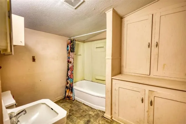 a kitchen with stainless steel appliances a stove top oven a sink a window and cabinets