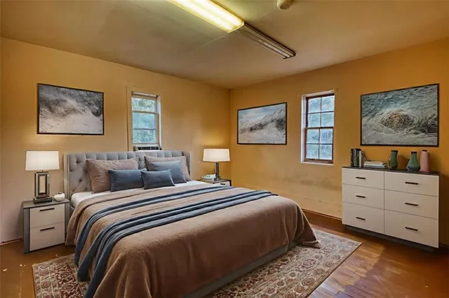 a bedroom with a bed and a painting on the wall