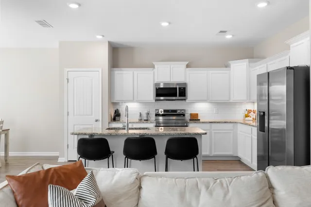 a kitchen with stainless steel appliances a stove a sink a microwave a refrigerator and cabinets