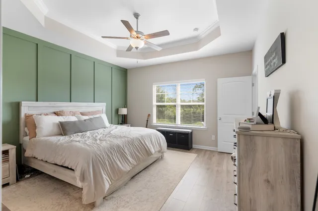 a bedroom with a large bed and a chandelier