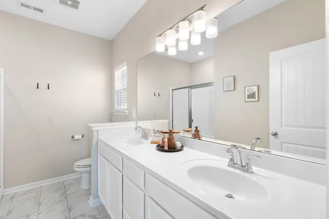 a bathroom with a toilet a sink and mirror