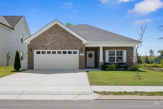 a white house with a small yard and large trees
