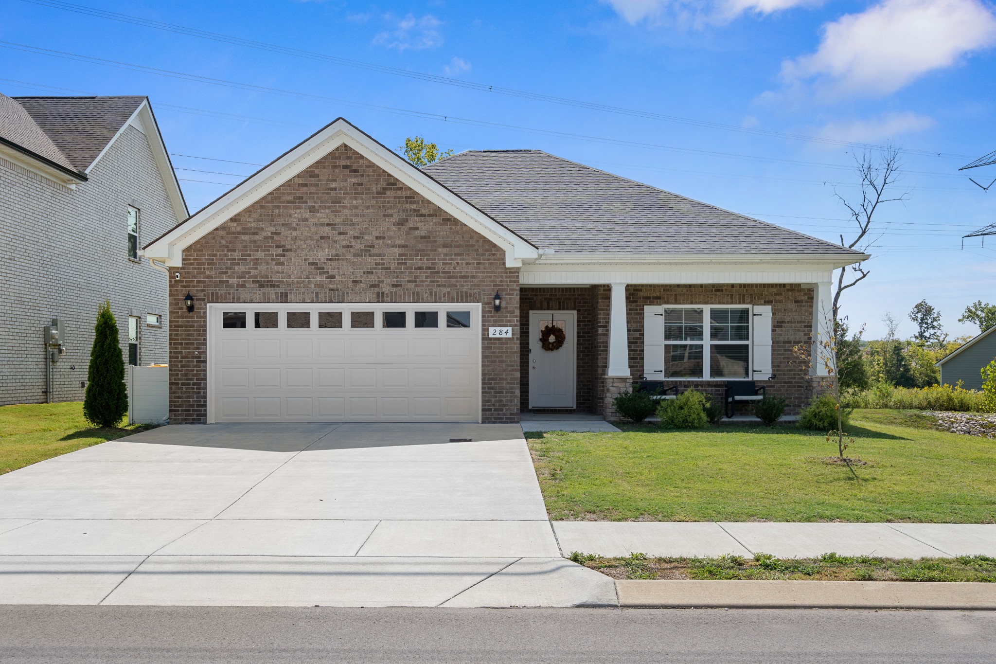 284 Thorpe Drive Spring Hill, TN 37174 - Photo 3 of 34 a white house with a small yard and large trees