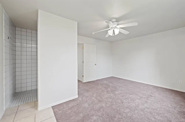 an empty room with closet and a chandelier fan