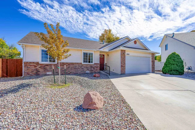 a view of a white house with a yard and a fountain