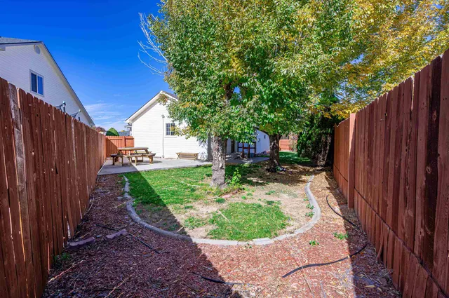 a view of a backyard with potted plants and wooden fence