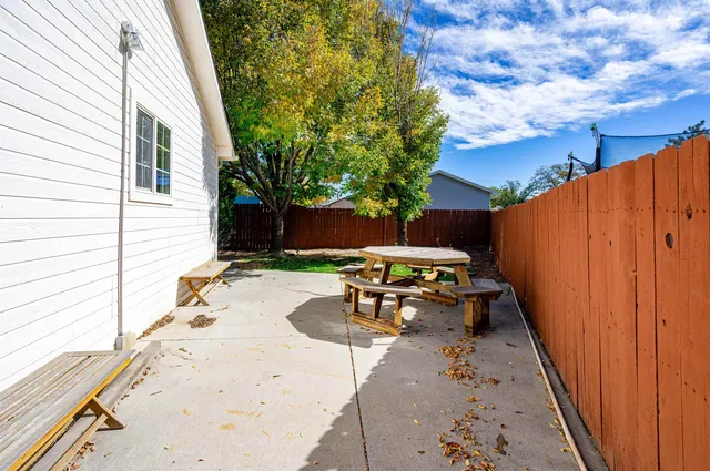 a view of a patio with table and chairs with wooden fence and plants