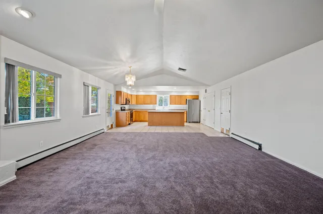 a view of an empty room with a window and fireplace