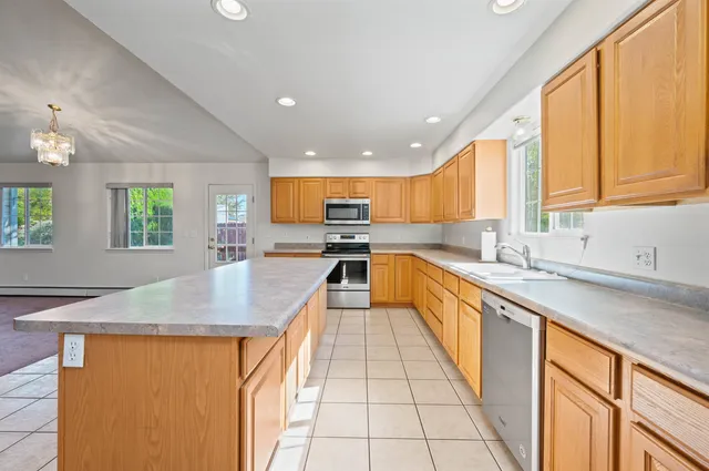 a kitchen with stainless steel appliances granite countertop refrigerator sink and cabinets