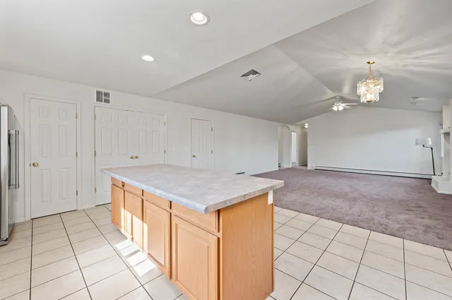 an empty room with kitchen view
