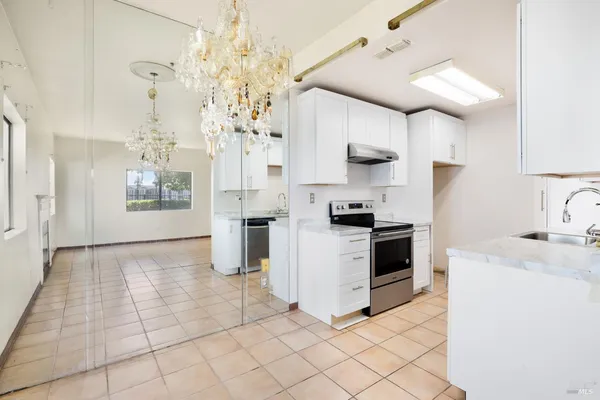 a kitchen with stainless steel appliances granite countertop a stove a sink and a refrigerator