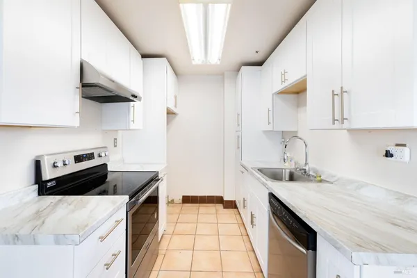 a kitchen with stainless steel appliances a sink a stove and a refrigerator