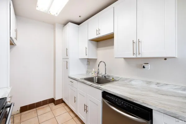 a kitchen with granite countertop a sink stove and cabinets