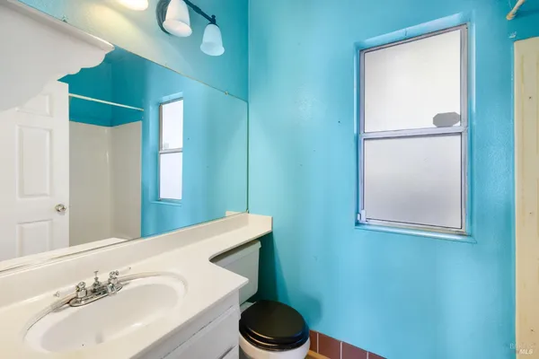 a bathroom with a toilet sink and mirror