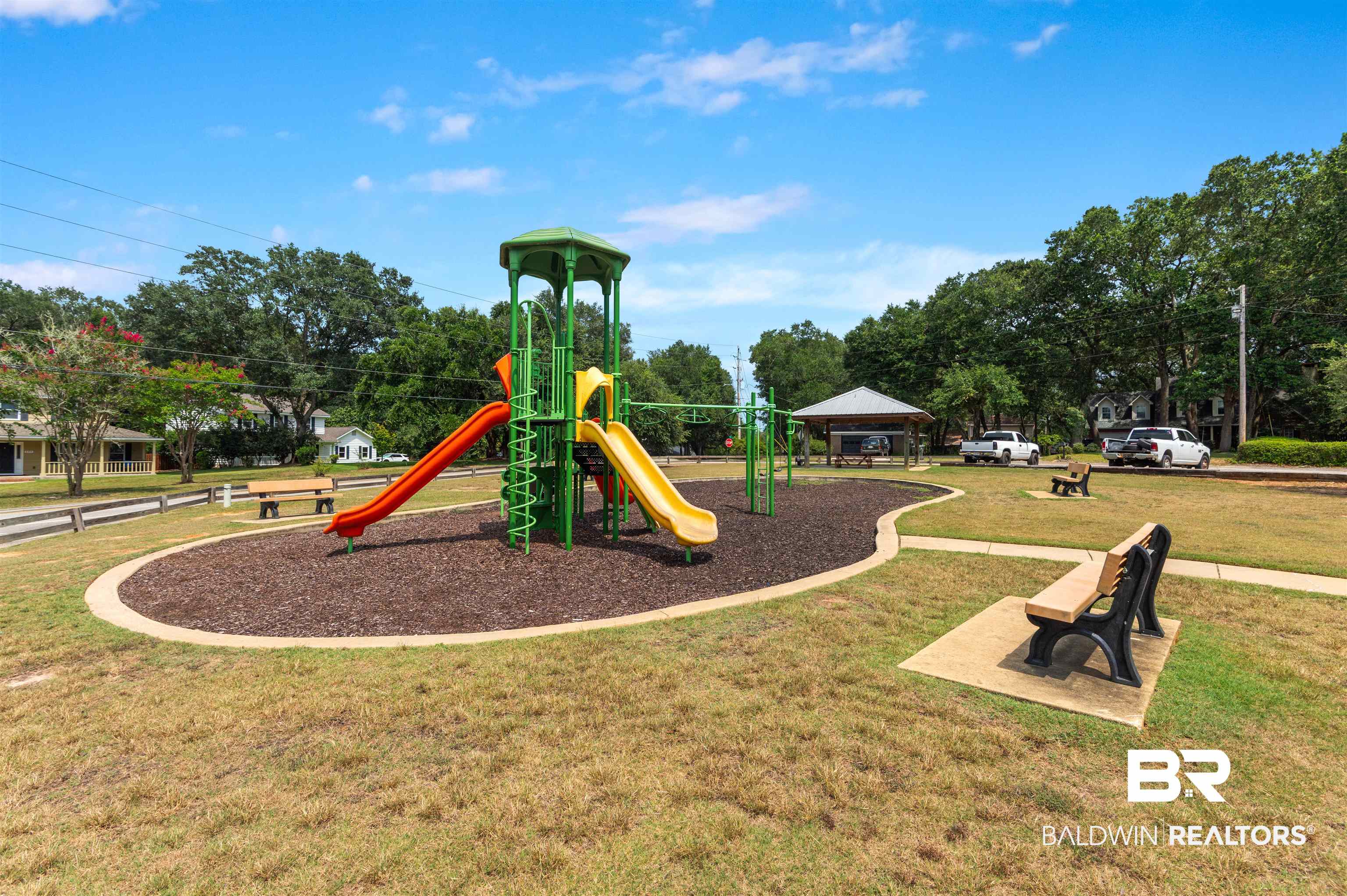 599 Ridgewood Drive Daphne, AL 36526 - Photo 39 of 41 Community playground featuring a multi-level play structure with multiple slides, a covered picnic area, and dedicated seating benches