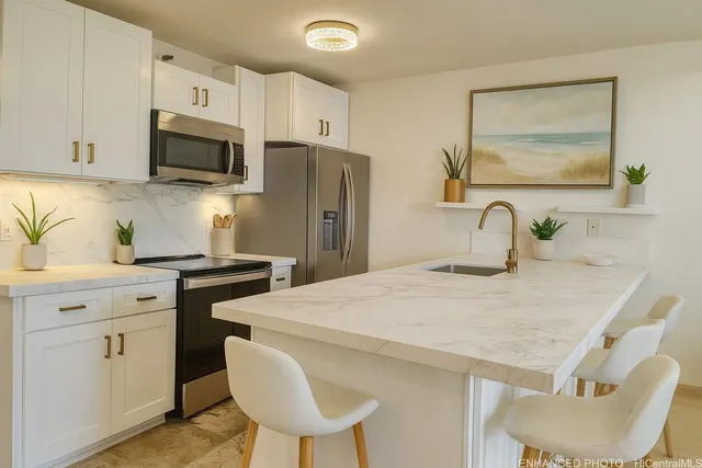 a kitchen with stainless steel appliances a stove a sink cabinets and a refrigerator