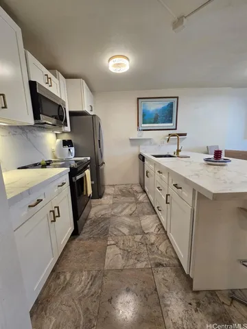 a kitchen with stainless steel appliances a sink stove refrigerator and cabinets
