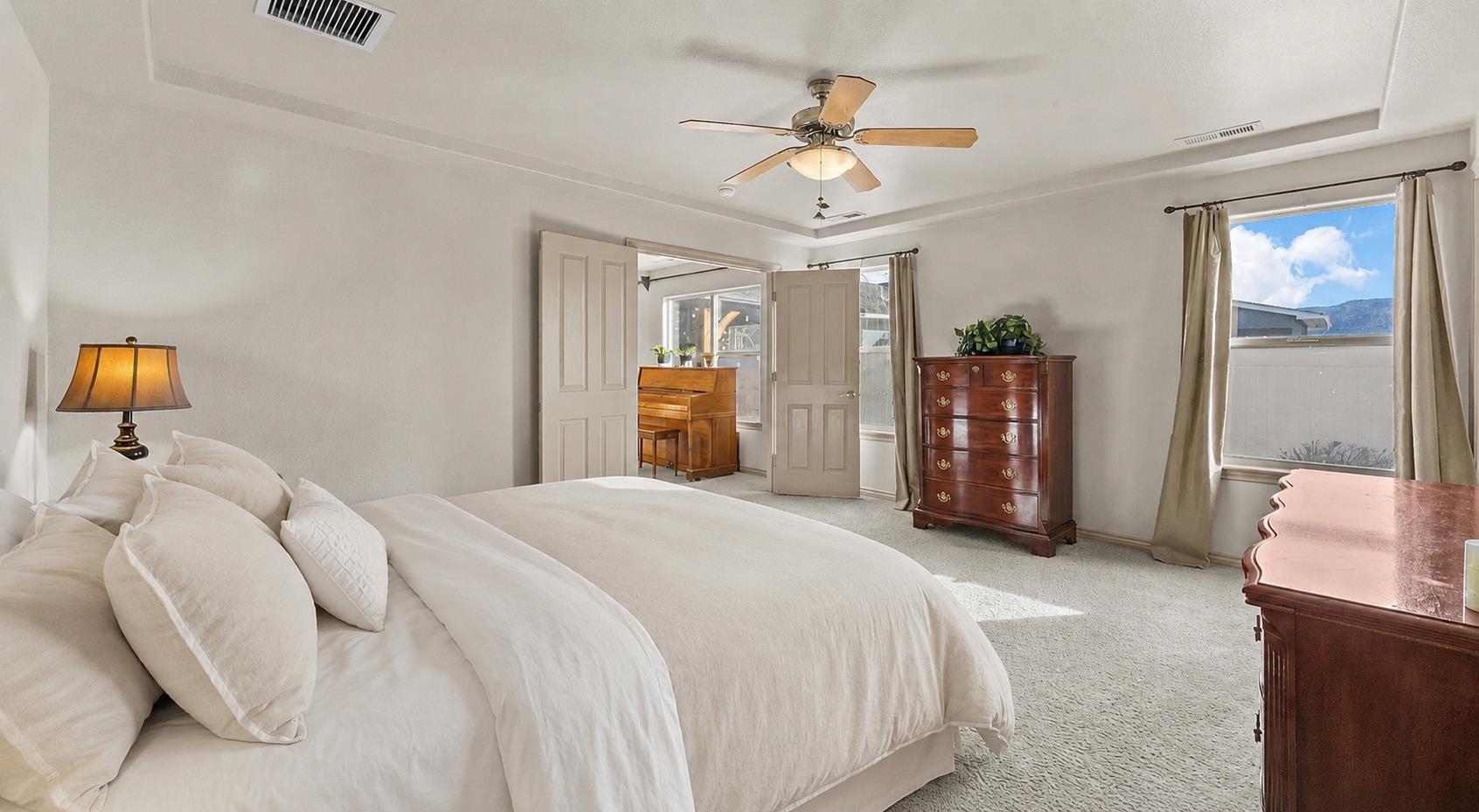 908 Kaley Street Fruita, CO 81521 - Photo 11 of 25 a spacious bedroom with a bed and ceiling fan