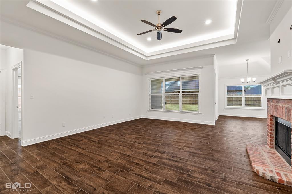 304 Prien Lk Loop Bossier City, LA 71111 - Photo 14 of 39 Spacious room featuring wood-finish flooring, a tray ceiling with recessed lighting and a ceiling fan, and multiple windows