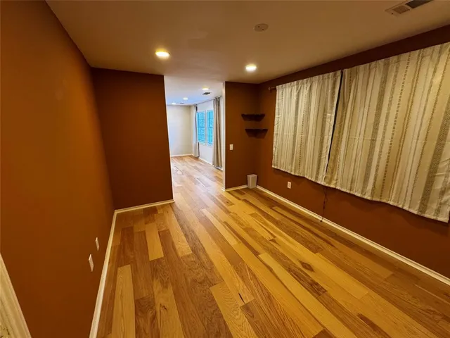a view of a room with wooden floor and window